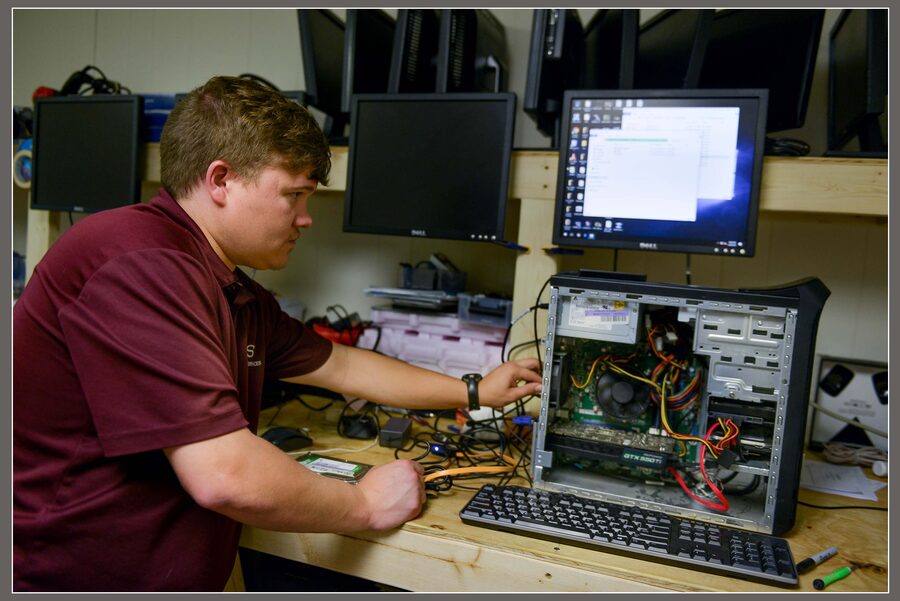 Technician repairing a desktop computer at the workbench